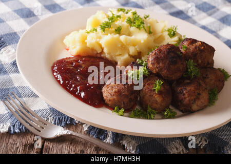 Boutique suédoise : boulettes de viande, sauce aux airelles avec garniture de pommes de terre sur une plaque horizontale de près. Banque D'Images