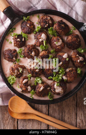 Swedish meatballs kottbullar avec sauce aux airelles libre sur une poêle. vertical Vue de dessus Banque D'Images