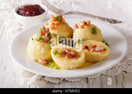 Délicieuses boulettes de pommes de terre aux lardons et au persil beurre garni de close-up sur une plaque horizontale. Banque D'Images