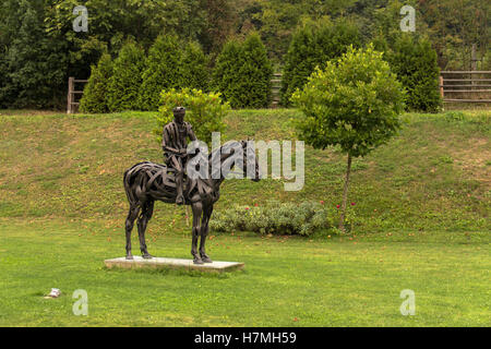 Cavalier sur un cheval Sculpture en métal, l'original rider sculpture réalisée sous la forme de bandes. Sur l'arrière-plan d'une herbe Banque D'Images