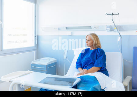 Portrait of a senior regarder par la fenêtre, à l'hôpital Banque D'Images