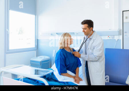 Doctor examining senior patient in hospital Banque D'Images