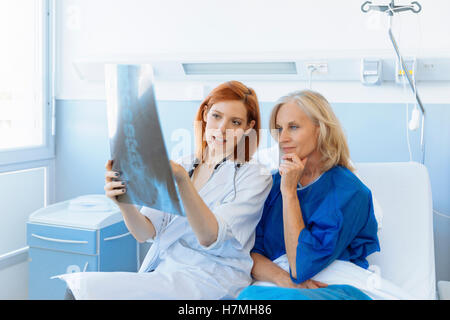 Doctor showing xray pour un senior patient in hospital Banque D'Images