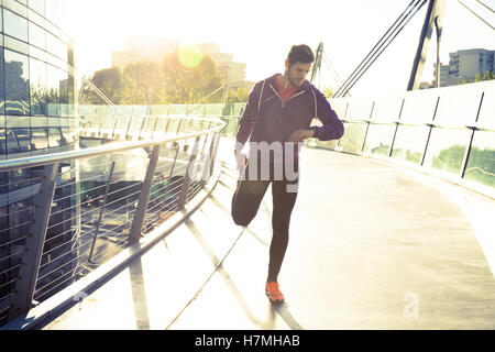 Homme runner stretching jambes avant de courir Banque D'Images