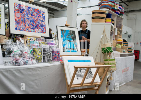 Jeune designer derrière un étal vente d'impressions et d'artisanat sur le Renegade Craft Fair une designer indépendante tenue de marché Banque D'Images