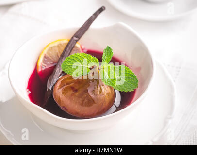 Fig poché au vin rouge à la menthe et à la vanille dans des couleurs claires Banque D'Images