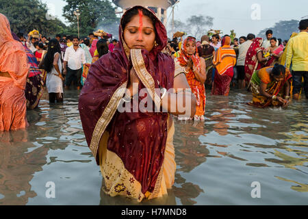 Kolkata, West Bengal, India, 6e Novembre 2016 : Chhath est un Hindu-Vedic célébration du festival qui tombe le quatrième jour après Diwali et sont célébrés pendant quatre jours. Lakhs de fidèles le dimanche prières offertes au soleil sur les ghats du Gange et d'autres rivières et plans d'eau dans Kolkata, Bengale occidental, à l'occasion de Chhath. Le jeûne à Kolkata, hommes et femmes se pressaient les ghats du Gange et se tint dans l'eau jusqu'à la taille pour offrir des prières pour le soleil couchant. Banque D'Images