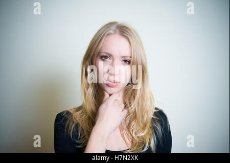 Jeune femme blonde thoughtful looking at camera, portrait Banque D'Images