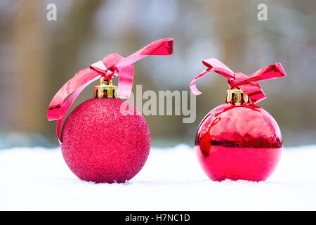 Deux boules de Noël rouge à l'extérieur dans la neige blanche Banque D'Images