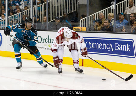 Le 24 septembre, 2011 ; San Jose, CA, USA ; l'aile gauche des Coyotes de Phoenix Viktor Tikhonov (26) patins avec les Sharks de San Jose rondelle derrière le défenseur Nick Petrecki (54) au cours de la première période chez HP Pavilion. Banque D'Images