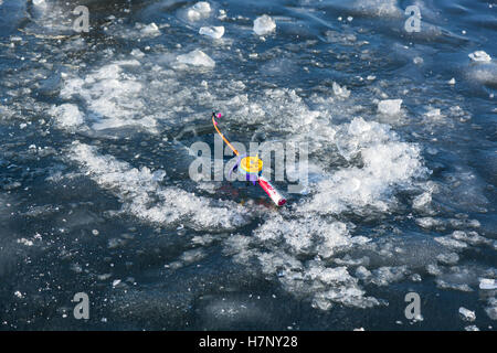 Canne à pêche pour la pêche d'hiver dans le trou, l'homme sur la pêche d'hiver, les gens sur la glace du lac gelé, pêcheurs, paysage urbain Banque D'Images