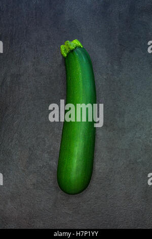 Courgette verte fraîche isolé sur fond noir en ardoise gris foncé Banque D'Images