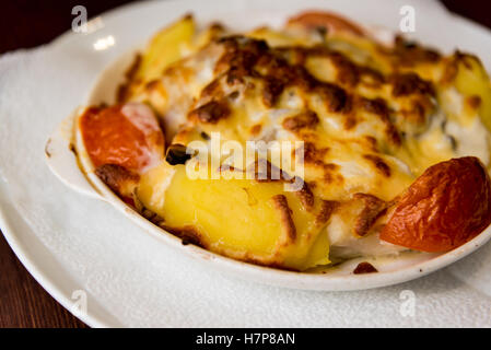 Les pommes de terre avec les tomates cuites avec du fromage Banque D'Images