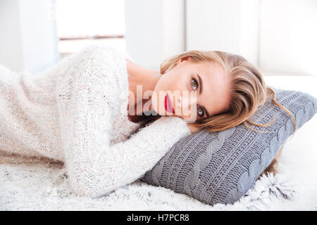 Portrait d'une belle jeune femme portant sur l'oreiller à l'intérieur Banque D'Images