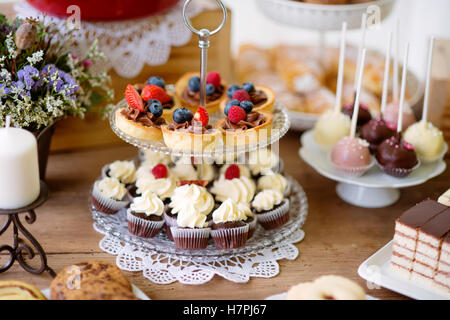 Table avec divers biscuits, tartes, gâteaux, petits gâteaux et cakepops Banque D'Images