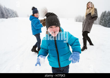 Maman avec ses deux fils à l'extérieur de jouer dans la neige. Banque D'Images