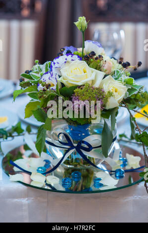 Article bouquet dans un vase sur la table dans le contexte de la paroi lumineuse Banque D'Images