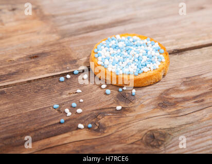 Célébration de naissance traditionnel néerlandais biscuit avec muisjes bleues sur fond de bois Banque D'Images