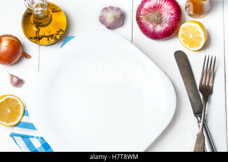 Assiette de porcelaine et rayures serviette sur fond de bois blanc Banque D'Images