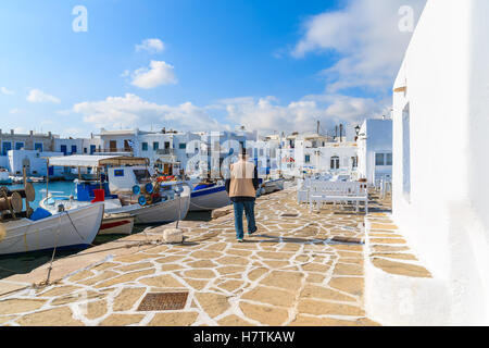 Vieux Pêcheur marchant le long de bateaux dans port de pêche de Naoussa, l'île de Paros, Grèce Banque D'Images