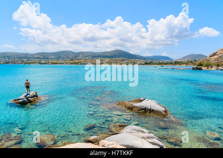 Jeune homme debout sur la roche dans une eau de mer turquoise de Kolymbithres beach, l'île de Paros, Grèce Banque D'Images