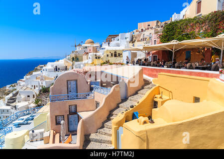 OIA, Santorini Island - 23 MAI 2016 : maisons et terrasse de restaurant de touristes dans la ville d'Oia sur l'île de Santorin, Grèce. Banque D'Images