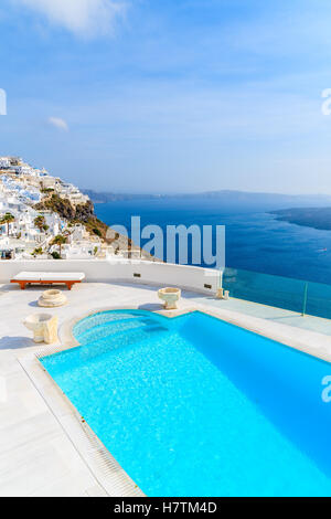 Vue sur la caldeira et la piscine de luxe en premier plan, typique de l'architecture blanche d'Imerovigli village sur l'île de Santorin, Grèce. Banque D'Images