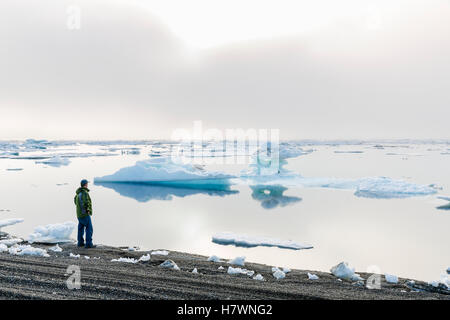 Un homme au bord de l'océan Arctique à l'extérieur, vers le coucher de soleil à travers un épais brouillard, Barrow, versant nord, l'Alaska arctique, USA, l'été Banque D'Images