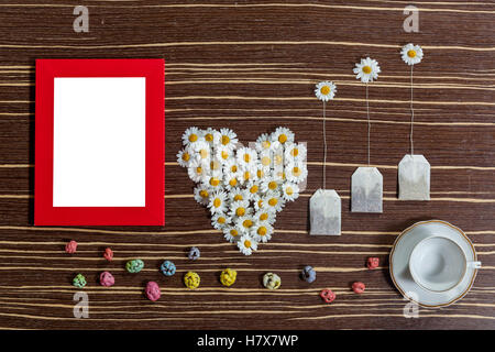 Composition de fleurs et de thé. Le plateau d'origine et composition de fleurs sur une table en bois. Il y a un coeur de la camomille, et ar Banque D'Images