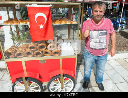 BODRUM, TURQUIE - 6 octobre, 2016 : vendeur de rue se trouve à côté de son panier à pain simit turc traditionnel de vente. Banque D'Images