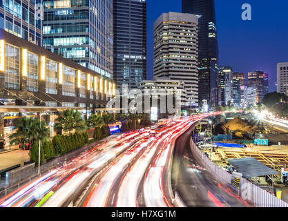 Le trafic lourd dans le quartier des affaires de Jakarta le long de l'avenue principale, Jalan Sudirman, de nuit en Indonésie capitale Banque D'Images