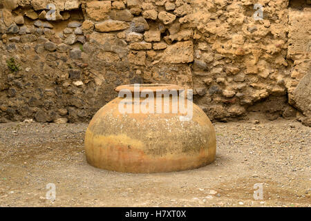 Amphores antiques sur la toile de fond d'un mur de pierre en ruines de Pompéi. Banque D'Images
