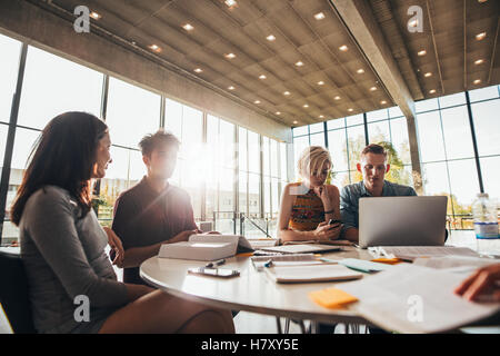 amis universitaires étudiant avec des livres et un ordinateur portable. Groupe d'étudiants assis à table dans la bibliothèque. Banque D'Images