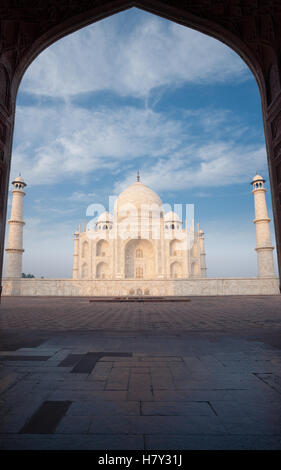 Le marbre blanc du Taj Mahal pans par la silhouette d'orient répondre grande porte avec personne présente sur un ciel bleu, la journée à Agra Banque D'Images