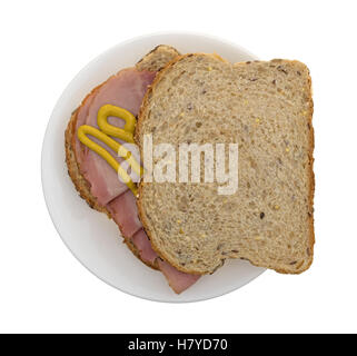 Vue de dessus d'un sandwich au jambon fumé au pommier avec de la moutarde sur le pain de blé au sommet d'un plateau isolé sur un fond blanc. Banque D'Images