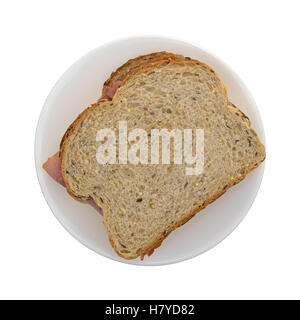 Vue de dessus d'un sandwich au jambon fumé applewood pain de blé sur une plaque au sommet isolé sur un fond blanc. Banque D'Images