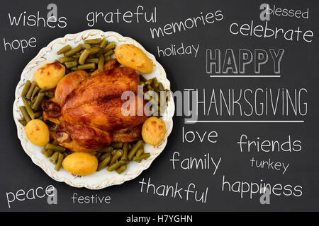 Capture d'un grand angle d'un dindon rôti sur un plateau en céramique ronde placée sur une surface gris foncé, le texte joyeux thanksgiving écrit en Banque D'Images