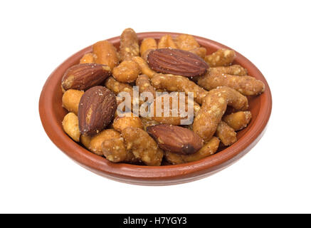 Un petit bol rempli d'énergie trail mix mélange d'arachides, amandes et sésame sticks isolé sur un fond blanc. Banque D'Images