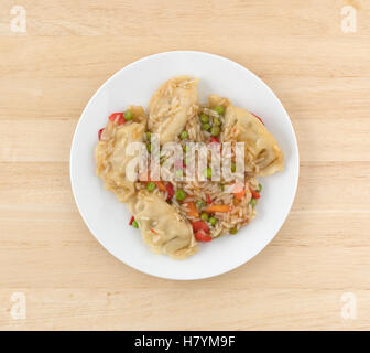 Vue de dessus d'un four à micro-ondes potstickers végétarien repas sur une plaque au-dessus d'une table en bois. Banque D'Images