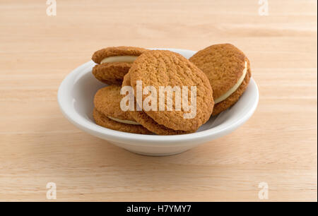 Un bol rempli de cheesecake cookies potiron au sommet d'une table en bois. Banque D'Images