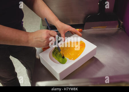 Peinture d'un travailleur à l'aide de moule chocolat chocolat de couleur Banque D'Images