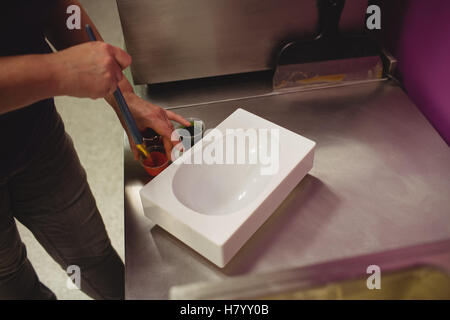 Peinture d'un travailleur à l'aide de moule chocolat chocolat de couleur Banque D'Images