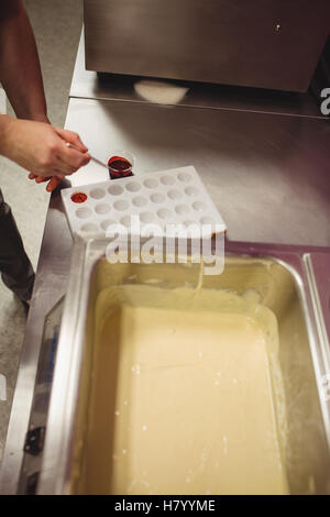 Peinture d'un travailleur à l'aide de moule chocolat chocolat de couleur Banque D'Images