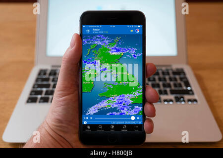 À l'aide d'iPhone smartphone pour afficher l'image radar météo de pluie à travers le Royaume-Uni Banque D'Images