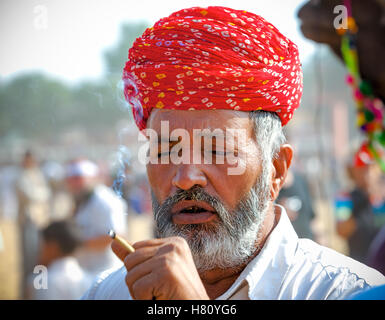 Portrait d'un homme indien du Rajasthan fumeurs non identifiés assiste à la foire de Pushkar, Inde Banque D'Images