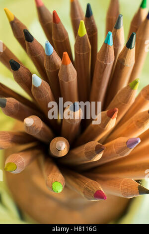 Bouquet de crayons de couleur en bois placés dans des porte-cuvette en céramique Banque D'Images