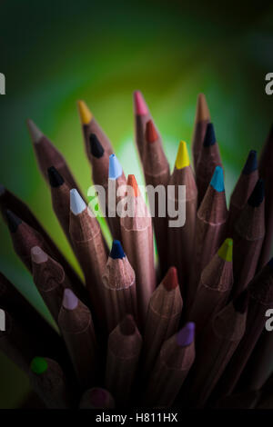 Bouquet de crayons de couleur en bois placés dans des porte-cuvette en céramique Banque D'Images