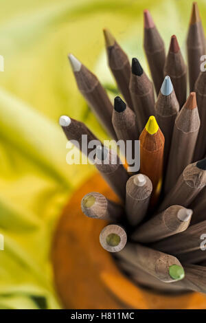 Bouquet de crayons de couleur en bois placés dans des porte-cuvette en céramique Banque D'Images