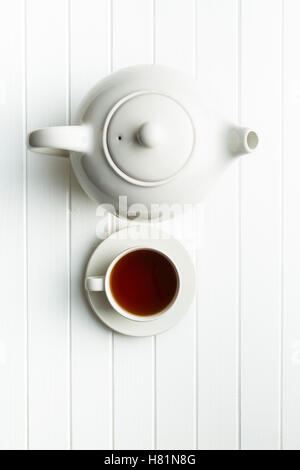 Une tasse de thé noir et blanc théière sur table. Vue d'en haut. Banque D'Images