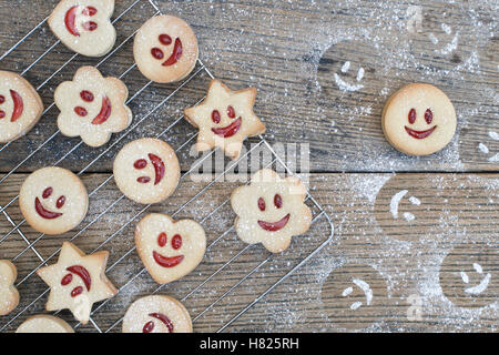 Jammie Dodgers fait maison. Biscuits au visage souriant et sucre glace impressions sur bois Banque D'Images